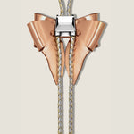 Rose gold and silver bow-shaped bolo tie on a beige background