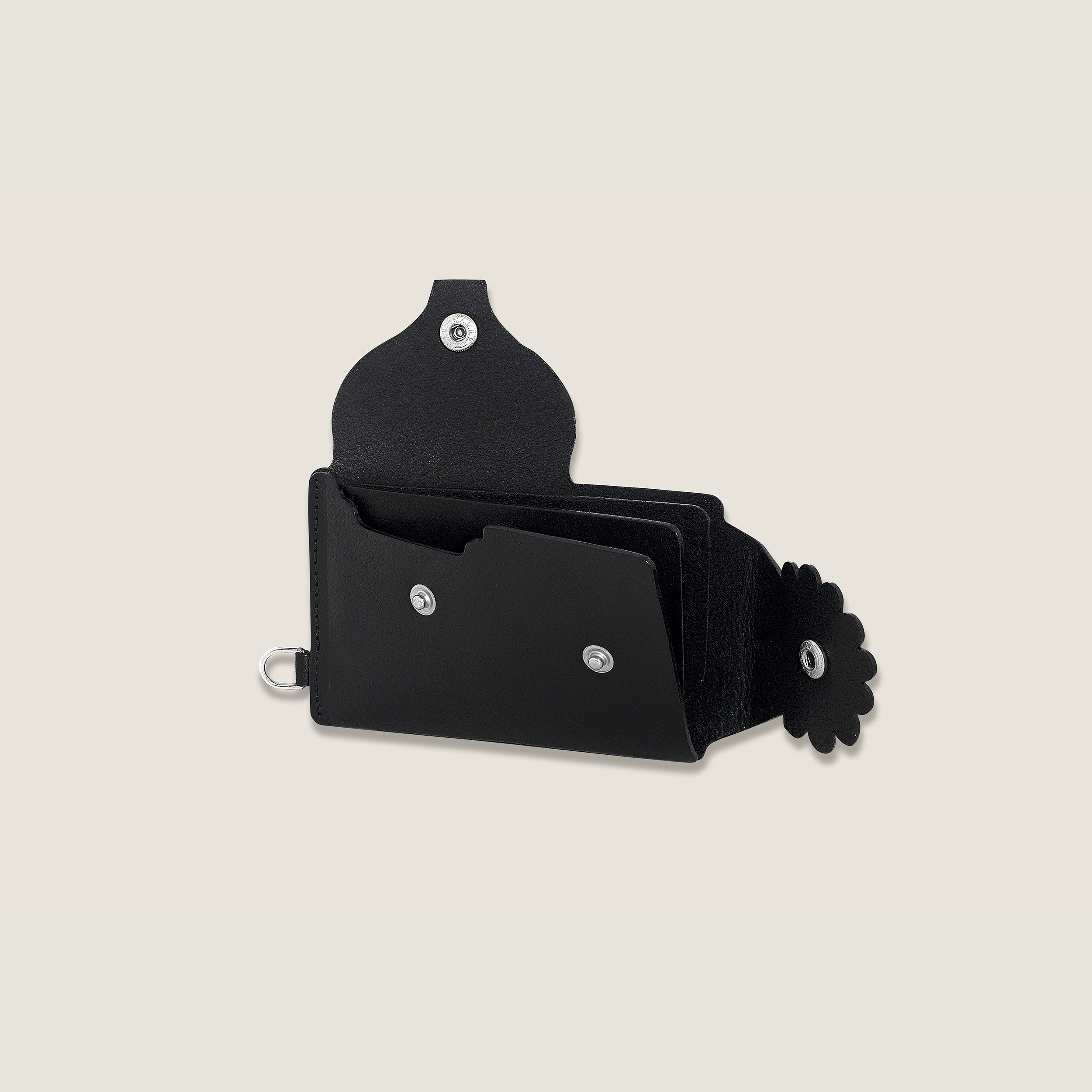 Black leather wallet with interior dividers for cards and flower accents on a beige background