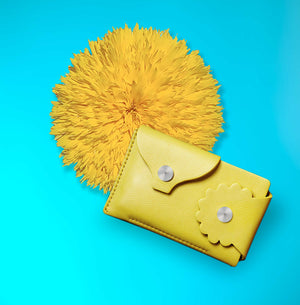 Marrs Makers Marigold Yellow Leather Wallet. Bright turquoise background color with large sunflower in this product shot.